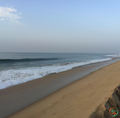 A sandy beach with waves crashing on it