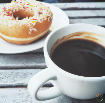 A cup of coffee next to a donut and a donut