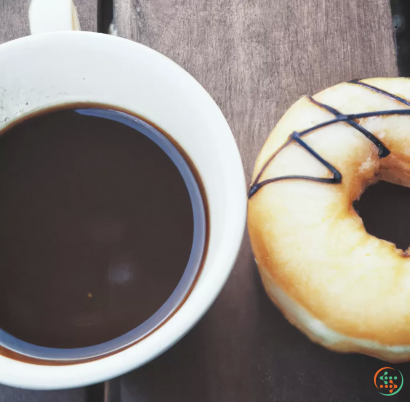 A cup of coffee next to a donut