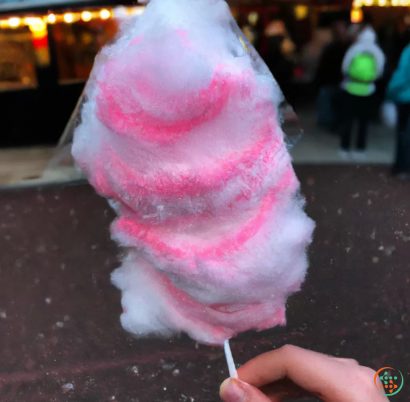 A hand holding a pink ice cream cone