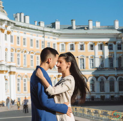 A man and woman kissing in front of a building