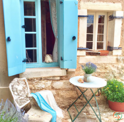 A cat sitting on a chair outside a blue door