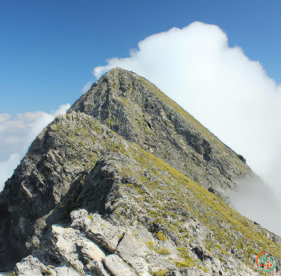 A mountain with a cloud in the sky