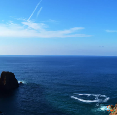 A body of water with a rock in the middle