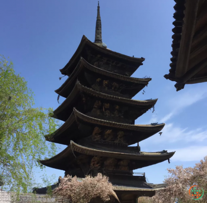 A tall tower with a pointed top with K?fuku-ji in the background